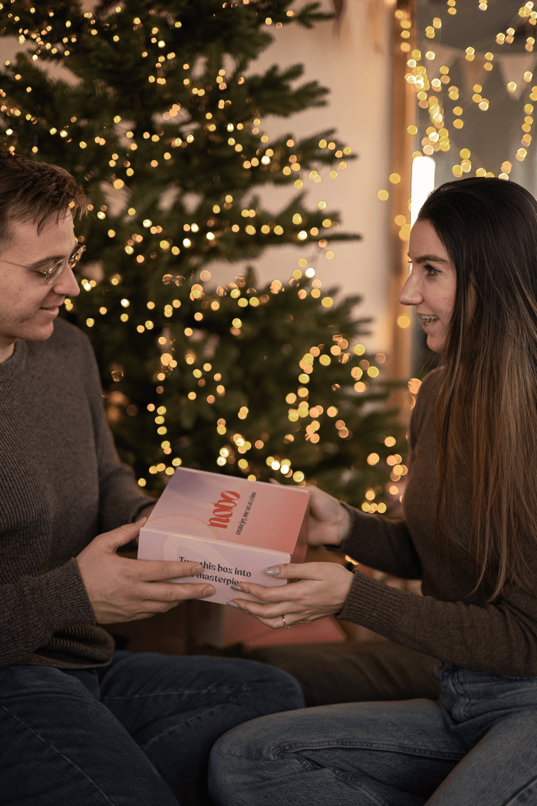 couple on christmas background giving each other presents